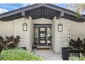 Stylish front entrance with modern lighting, a decorative brick surround, and elegant planters for a welcoming feel at 2756 Summerfield Rd, Winter Park, FL 32792