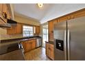 Well-lit kitchen with stainless steel appliances, wooden cabinets, and a tile backsplash at 309 Panama Cir, Winter Springs, FL 32708