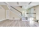 Spacious living room with wood-look floors, staircase with white railings and black trim, and a mirrored wall feature at 315 Glenview Blvd # 3, Daytona Beach, FL 32118