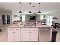Open-concept kitchen island with a stainless steel dishwasher, sink, and granite countertops at 318 Briarbrook Ln, Haines City, FL 33844