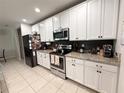 Modern kitchen featuring stainless steel appliances, granite countertops, and ample white cabinetry at 318 Briarbrook Ln, Haines City, FL 33844