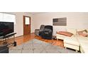 Inviting living room featuring hardwood floors, a comfortable couch, a cozy armchair, and an American flag art piece at 320 Lakeview St # 208, Orlando, FL 32804