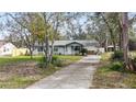 Single-story home with a stone facade and a long driveway leading to the attached garage at 35724 Dawn Dr, Leesburg, FL 34788