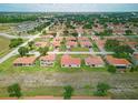 An aerial view of a neighborhood featuring well-maintained homes with red tile roofs and green lawns at 459 Cinnamon Dr, Kissimmee, FL 34759