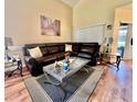 Cozy living room features a leather sectional sofa, a glass coffee table, and stylish decor at 4652 Oak Arbor Cir, Orlando, FL 32808