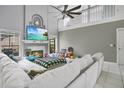 Spacious living room with fireplace, entertainment center, high ceilings, white sectional sofa, and many toys at 468 Wexdon Ct, Lake Mary, FL 32746