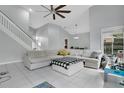 Bright living room with vaulted ceilings, tile floors, stairs, and comfortable white sectional sofa at 468 Wexdon Ct, Lake Mary, FL 32746