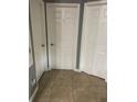 Hallway view featuring three doors, each easily accessible with neutral tile floors at 4843 Pierce Arrow Dr, Apopka, FL 32712