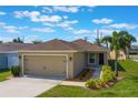 Charming single-story home featuring a two-car garage, neutral paint, manicured lawn, and lovely landscaping at 490 Pentas Ln, Haines City, FL 33844