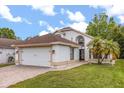Charming single-Gathering home with a well-manicured lawn, two car garage, and tropical landscaping on a sunny day at 5672 Parkview Lake Dr, Orlando, FL 32821