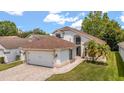 Charming single-Gathering home with a well-manicured lawn, two car garage, and tropical landscaping on a sunny day at 5672 Parkview Lake Dr, Orlando, FL 32821
