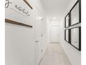 Bright hallway with tile floors, white walls, and modern black decorative mirrors at 6834 Wilson Hammock Ave, Groveland, FL 34736