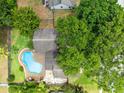 Aerial view of home featuring a backyard pool surrounded by mature trees and landscaping at 7249 Abbey Ln, Winter Park, FL 32792