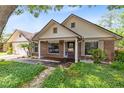 Inviting one-story brick home showcasing a cozy front porch and a lush green landscape at 7249 Abbey Ln, Winter Park, FL 32792
