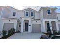 Inviting townhome featuring a modern facade, a private garage, and a well-maintained front yard at 7612 Danube Rd, Kissimmee, FL 34746