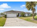 Well-maintained single Gathering home with a two car garage and a charming front yard with palm trees at 7760 Indian Ridge N Trl, Kissimmee, FL 34747