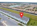 Aerial view showcasing the community's layout with townhomes, parking and pond at 8944 Sydney Ave, Kissimmee, FL 34747