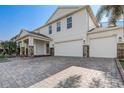 Lovely two-story home with a three-car garage, stone accents and brick paver driveway at 10231 Lenox St, Clermont, FL 34711