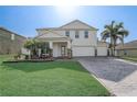 Beautifully landscaped two-story home with a three-car garage and a brick paved driveway at 10231 Lenox St, Clermont, FL 34711