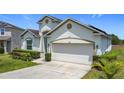 Inviting single-Gathering home boasts a two-car garage and a well-maintained front yard under a clear blue sky at 1061 Suffragatte Cir, Haines City, FL 33844
