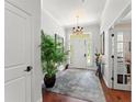 Bright foyer with wood floors, a chandelier, and a large potted plant, creating an inviting entrance to the home at 1184 Fern Ave, Orlando, FL 32814
