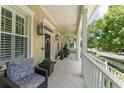 Spacious front porch with cozy seating, elegant columns, and decorative lanterns, perfect for relaxing outdoors at 1184 Fern Ave, Orlando, FL 32814