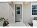 Up close exterior view of a light green front door with a window, set within a white frame at 11944 Sunsail Ave, Orlando, FL 32832