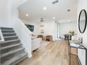 Open-concept living area with wood floors, neutral furniture, and a staircase leading upstairs at 11944 Sunsail Ave, Orlando, FL 32832
