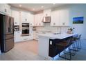 Bright kitchen with white cabinets, stainless steel appliances, and bar seating at 1340 Blue Stem Ln, Winter Park, FL 32792