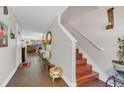 Entryway with wooden floors, staircase, decorative mirror, and plants at 13480 Applerose Ln # 19, Orlando, FL 32824