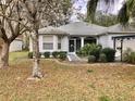 Beautiful home with a screened front entryway, tidy landscaping, and gray driveway at 144 Costa Mesa Dr, Lady Lake, FL 32159