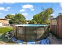 A backyard features an above-ground swimming pool and some surrounding trees and partial fence at 1508 Roger Babson Rd, Orlando, FL 32808
