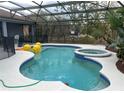 Inviting screened-in pool area with a spa and outdoor living space, perfect for relaxing and entertaining at 151 Prestwick Dr, Davenport, FL 33897