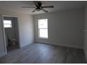 Bedroom featuring wood-look flooring, ceiling fan, and en-suite bathroom at 16648 Sw 25Th Ct, Ocala, FL 34473