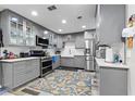 Modern kitchen with gray cabinets, stainless steel appliances and a stylish blue and gold rug at 170 Lago Vista Blvd, Casselberry, FL 32707