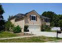 Charming two-story home with a stucco facade, manicured lawn, attached garage, and solar panels at 211 Hunt St, Clermont, FL 34711