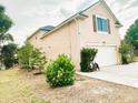 Exterior view of a home featuring a two car garage, side yard and light colored siding at 211 Hunt St, Clermont, FL 34711
