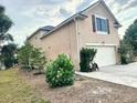 Exterior view of a home featuring a two car garage, side yard and light colored siding at 211 Hunt St, Clermont, FL 34711