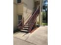 Exterior view of a building featuring a red staircase leading to the upper levels, offering convenient access at 2882 Club Cortile Cir # B, Kissimmee, FL 34746