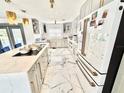 Bright kitchen with white cabinets, marble floors, and a modern, stainless steel refrigerator at 2932 Larson St, Kissimmee, FL 34741