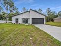 Contemporary home with dark trim and a well-maintained lawn and freshly poured driveway at 357 Marion Oaks Pass, Ocala, FL 34473