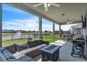 Relaxing covered patio with comfortable seating, outdoor kitchen, and picturesque views of the serene pond at 3961 Crawley Down Loop, Sanford, FL 32773