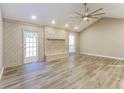 Bright living room featuring vaulted ceilings, stone fireplace, ceiling fan and wood-look floors at 4265 Old Colony Rd, Mulberry, FL 33860