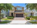 Beautiful two-story home showcasing a brick-paved driveway, and a two-car garage at 480 Lasso Dr, Kissimmee, FL 34747