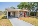 Cozy home featuring stone accents, a red door, and an attached carport with covered parking at 4827 Elese St, Orlando, FL 32811