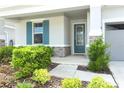 Inviting front porch with colorful shutters and stone accents for added curb appeal at 5089 Meadow Song Dr, Okahumpka, FL 34762