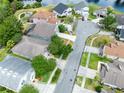 A high-level aerial view of the home, surrounded by trees and ponds in a residential community at 516 Brett Ct, Orlando, FL 32828