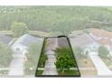 An aerial view of the home, showing its placement on the street and a mature shade tree at 516 Brett Ct, Orlando, FL 32828