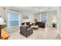 The bright living room features large windows, neutral decor, updated floors, and comfortable seating at 516 Brett Ct, Orlando, FL 32828
