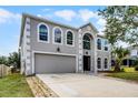 Two-story home featuring large windows, a two-car garage, a spacious driveway, and manicured landscaping at 520 Stonewall Ave, Haines City, FL 33844